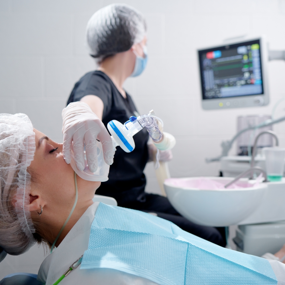 dentist placing nitrous oxide mask on patient