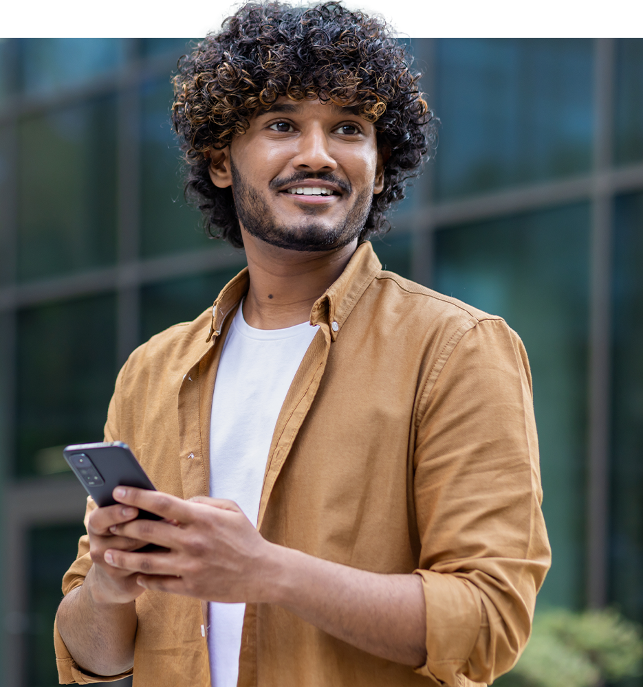 Smiling man with veneers on his phone
