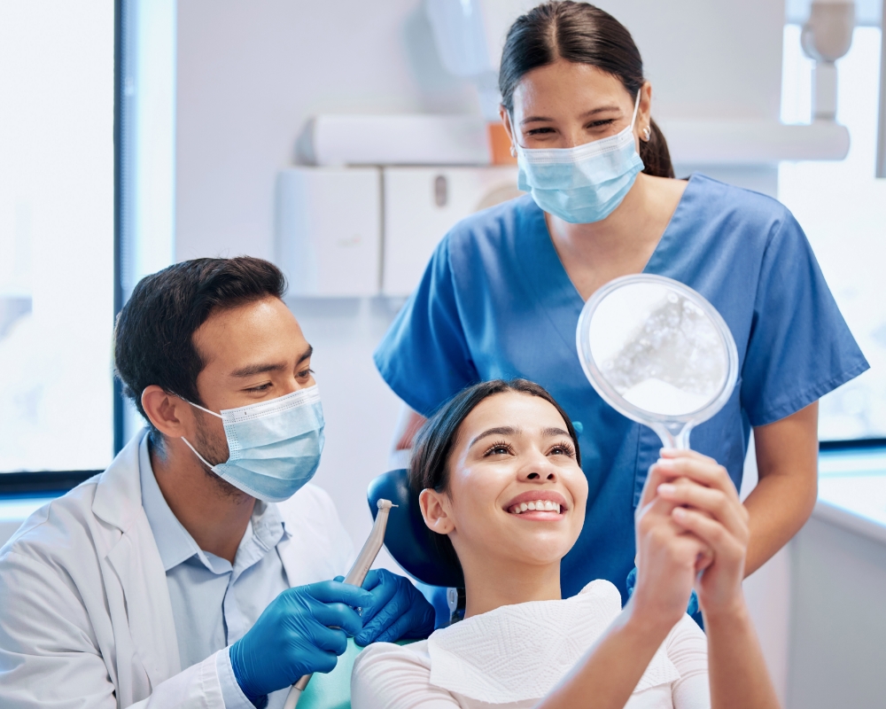 Smiling cosmetic dentistry patient looking in the mirror