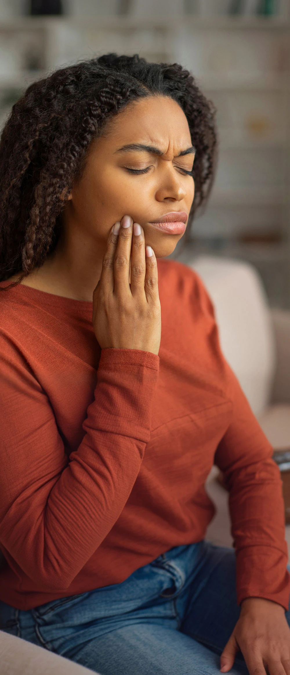 woman holding jaw in pain