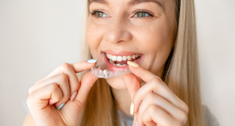 Woman putting in clear aligner