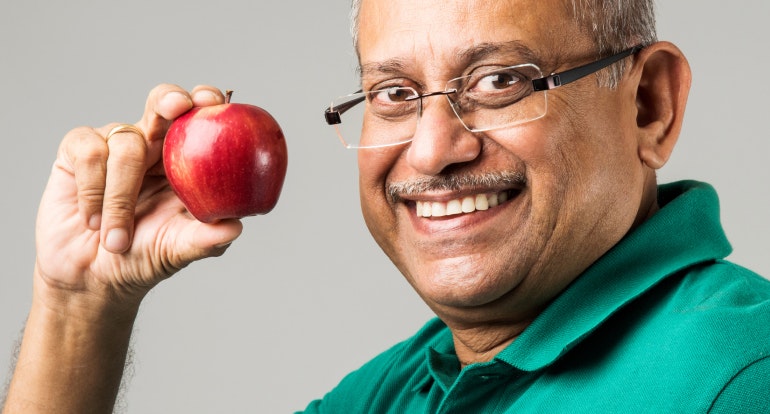 Smiling man holding an apple