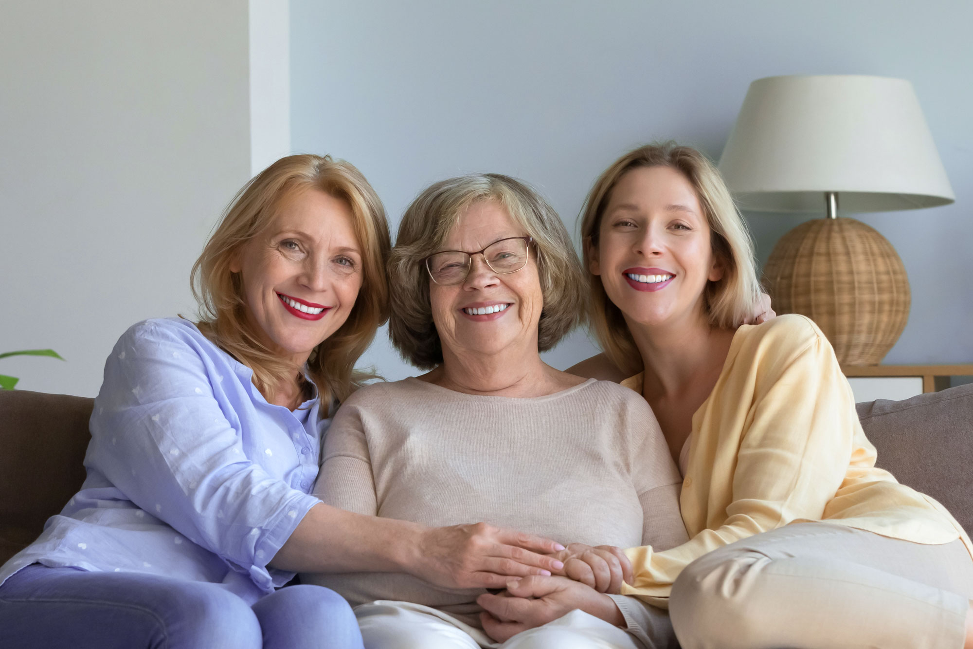 three women smiling together on a couch