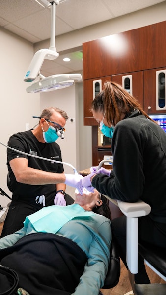 Dr. David Montz and dental hygienist performing treatment on a patient at Montz & Maher Dental Group