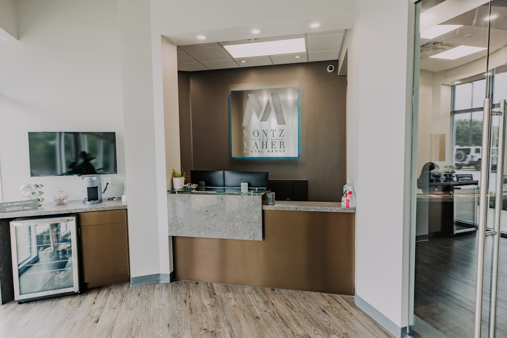 Reception area at Montz & Maher Dental Group featuring welcome desk and practice signage