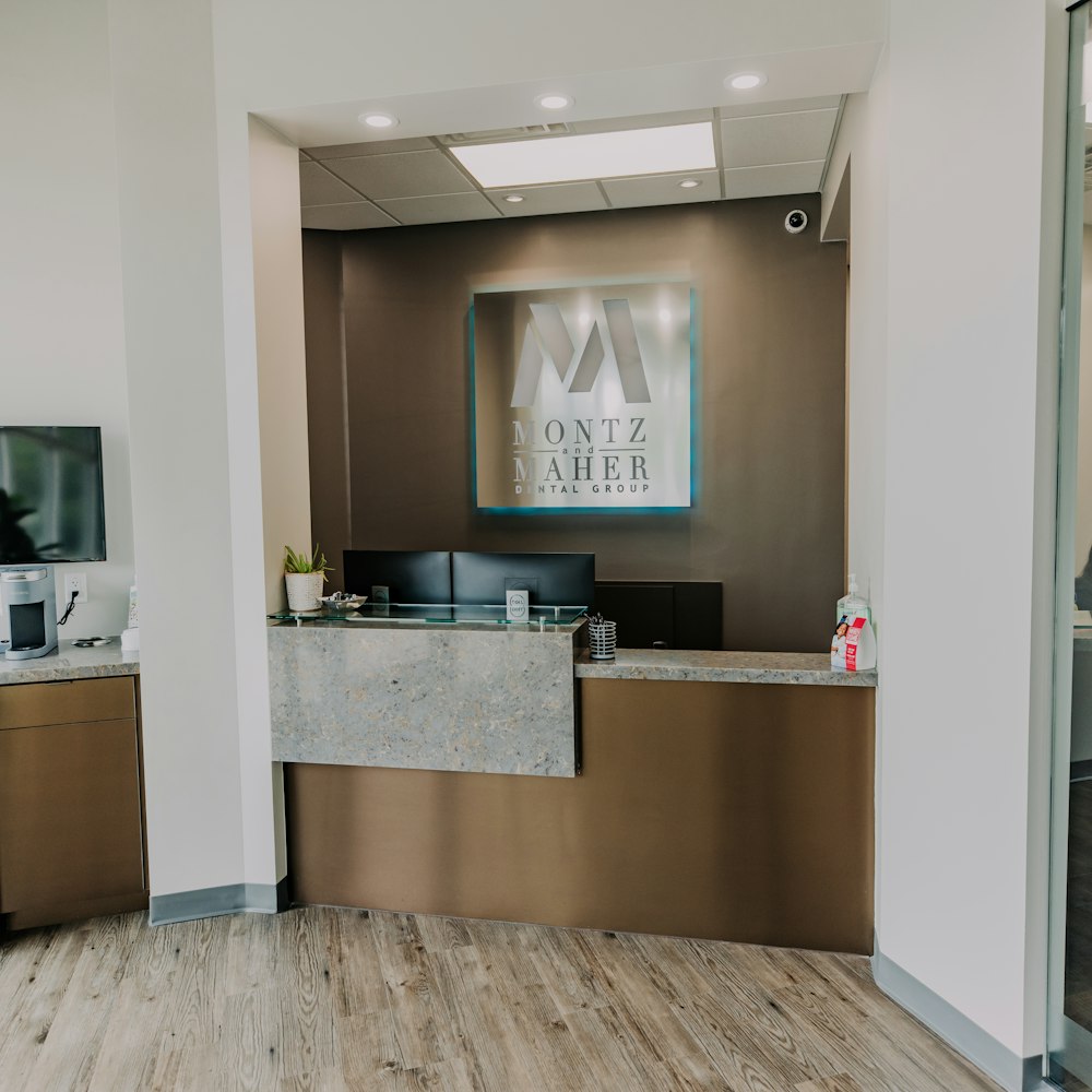 Reception area at Montz & Maher Dental Group featuring welcome desk and practice signage