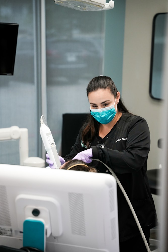 Dental assistant using iTero scanner during patient exam at Montz & Maher Dental Group