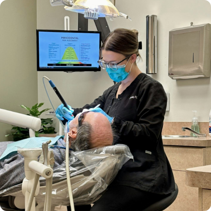 dental hygienist cleaning a patient's teeth