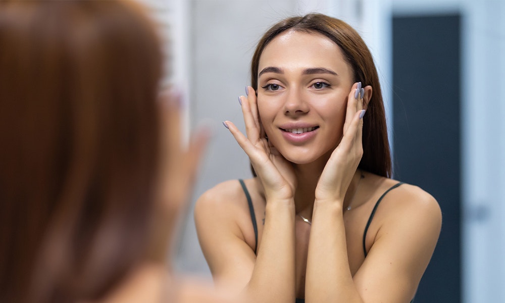 woman looking at her reflection in the mirror