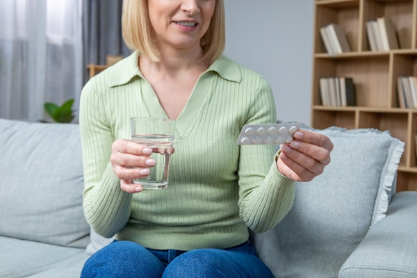 Woman looking at a pill pack