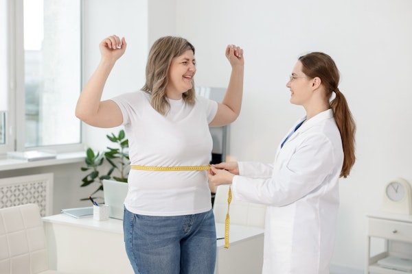 Woman getting her waist measured at a consultation