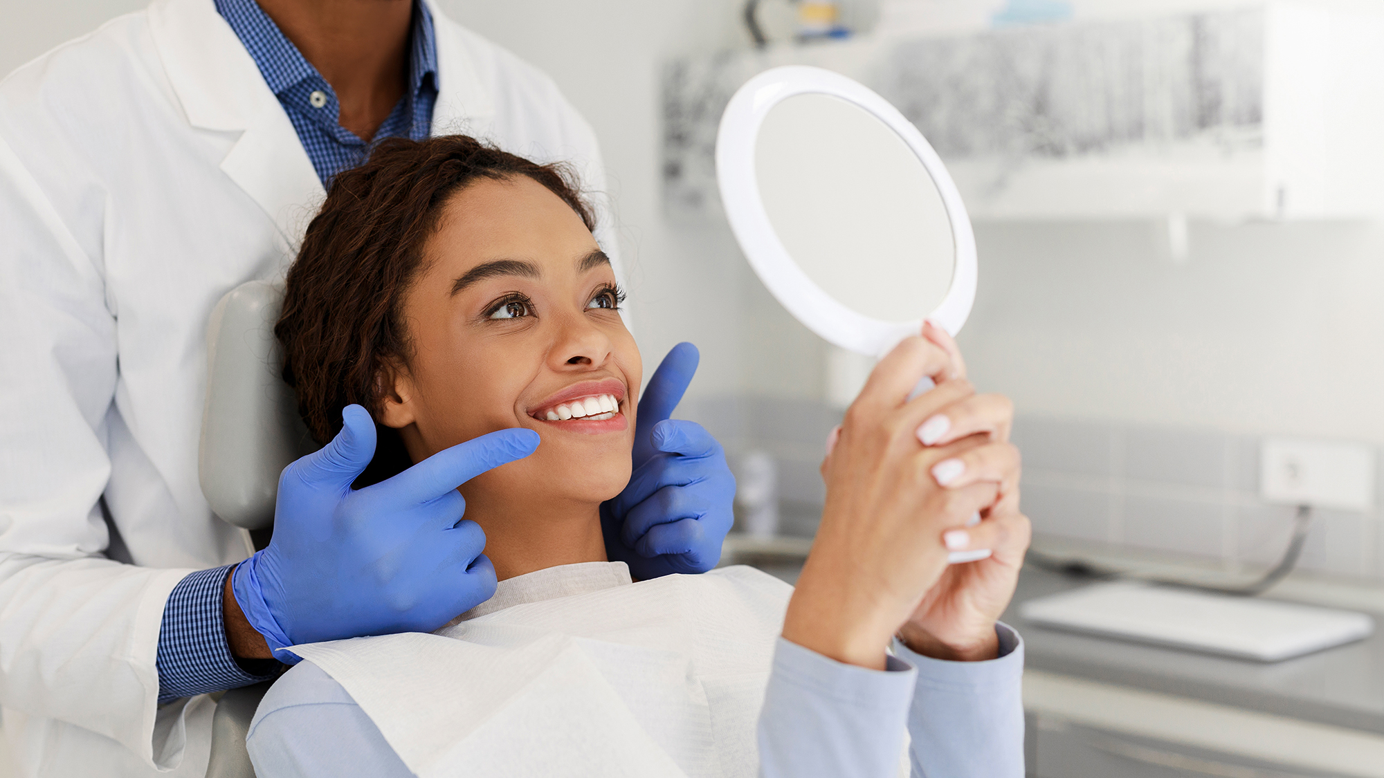 woman smiling in a handheld mirror