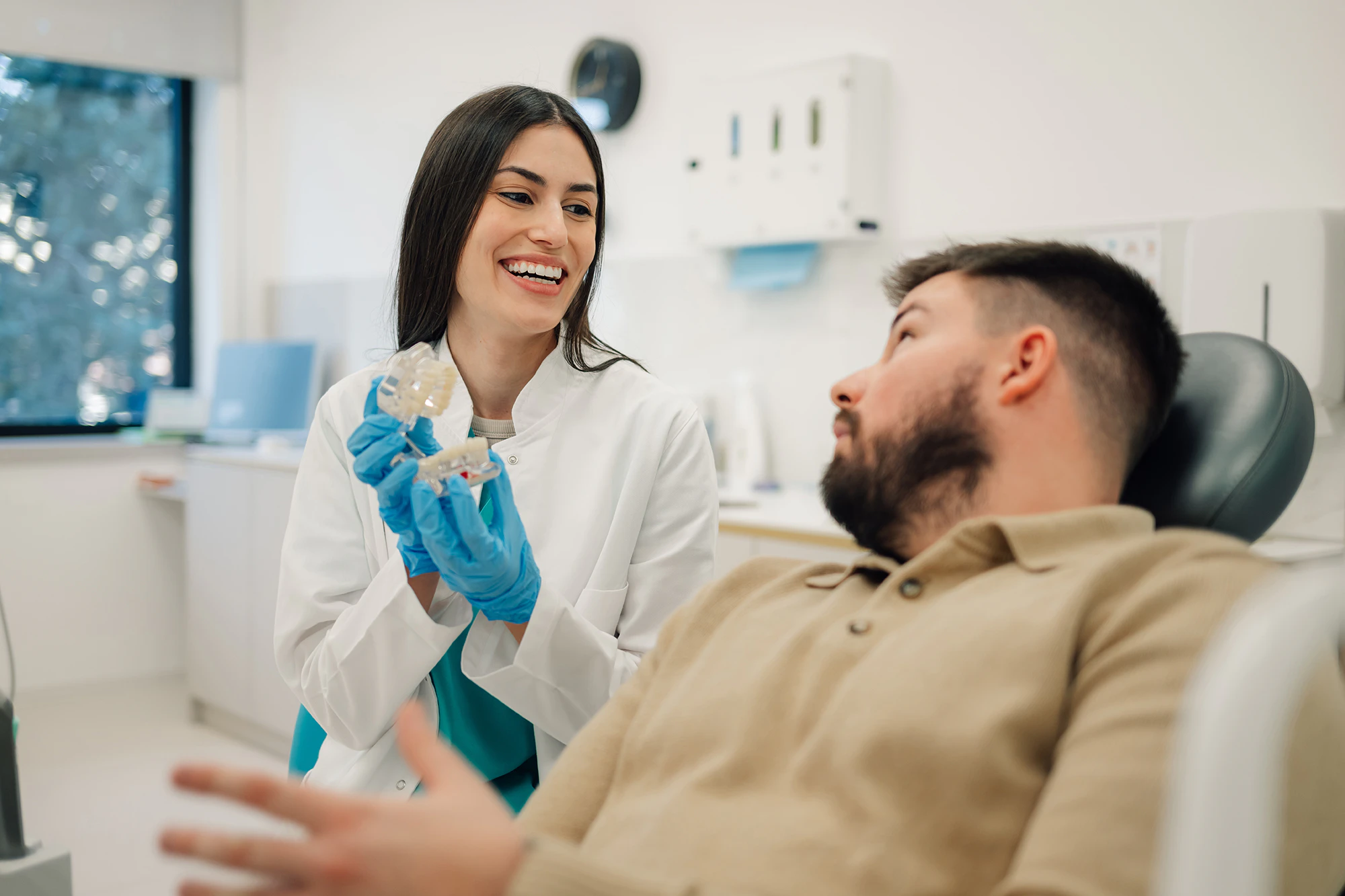 dentist showing patient a model of teeth