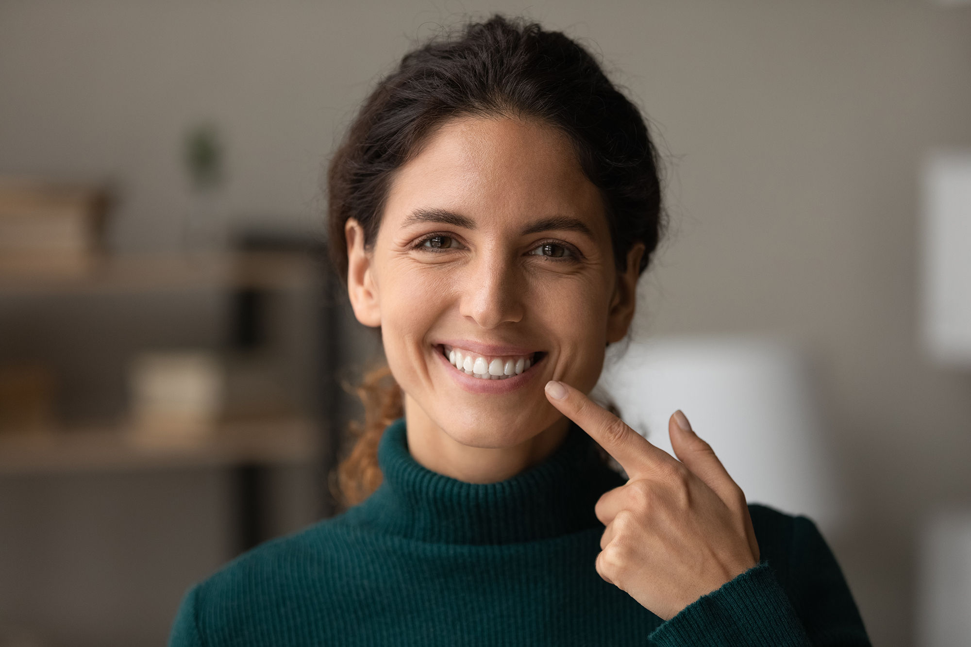 woman pointing to her smile