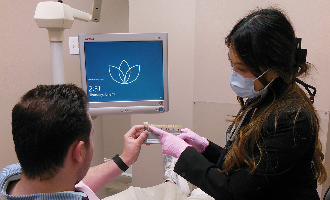 dentist showing patient veneer options