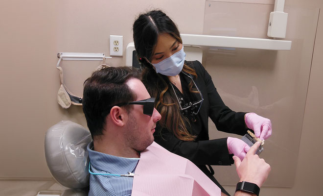 dentist showing patient veneer options