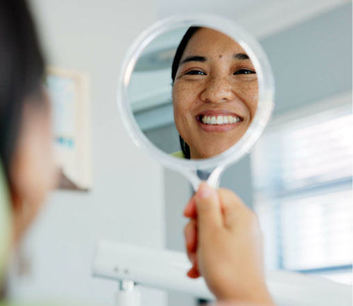 Smiling All-on-4 patient looking in the mirror
