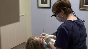 Patient getting periodontal maintenance with hygienist.