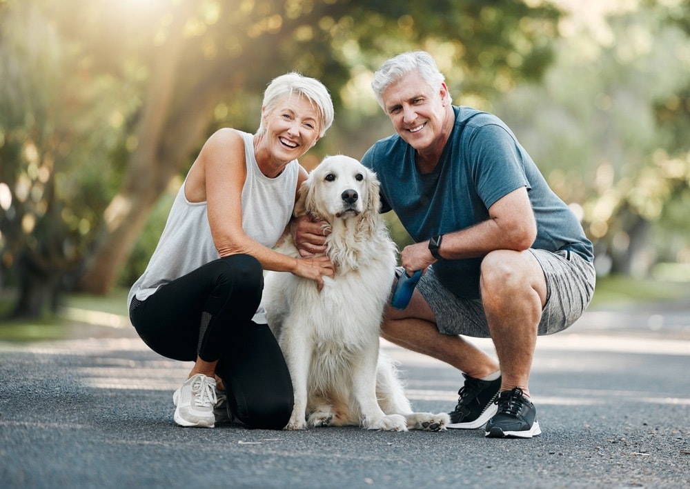 older couple smiling with their dog