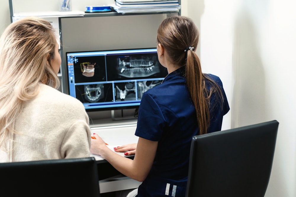 Dentist educating patient using dental software
