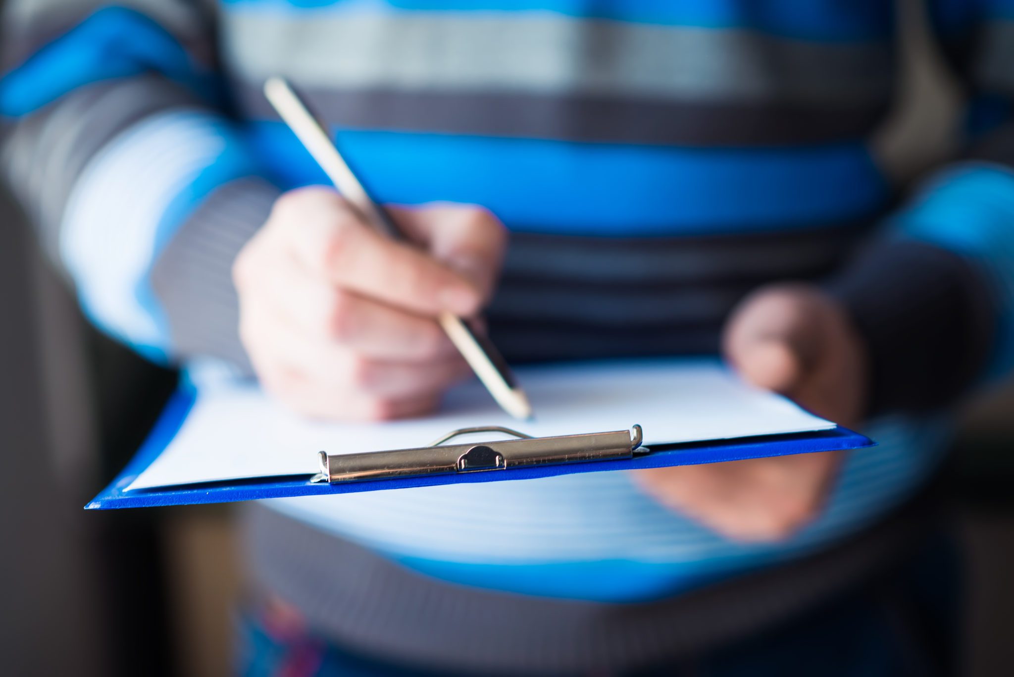 person in blue striped sweater filling out paperwork