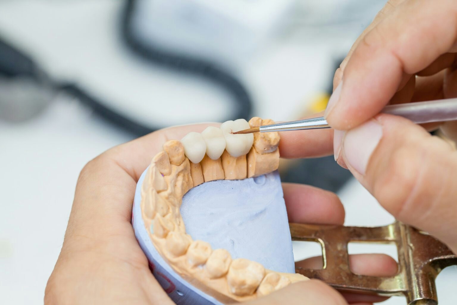 dentist holding a dental bridge