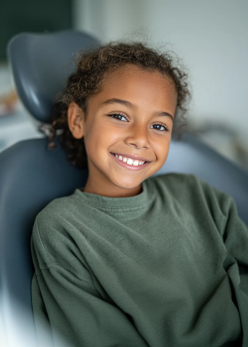 Smiling child seated in a dental chair