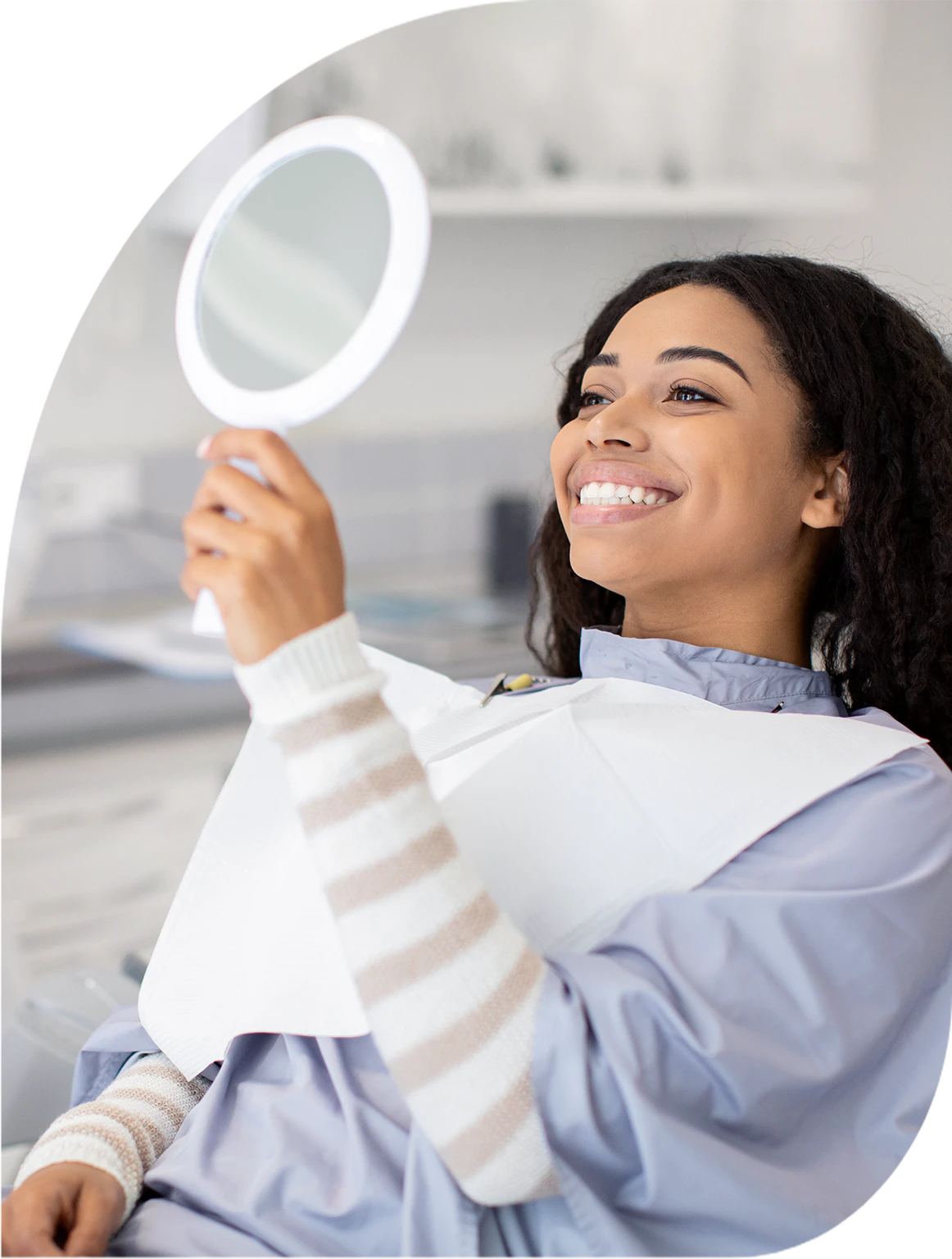 woman smiling in a handheld mirror