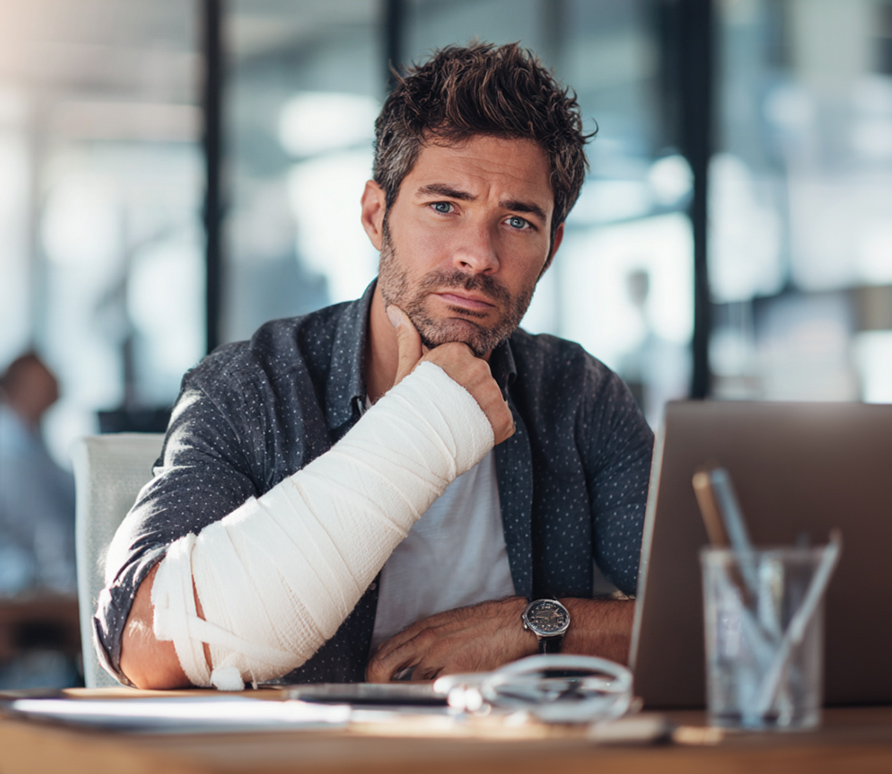 man with arm in cast working on laptop