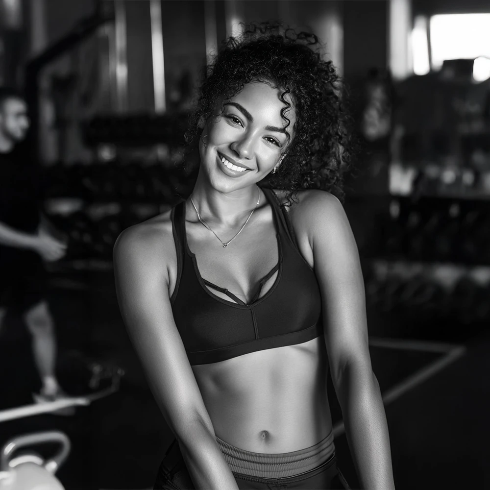 Black and white photo of a woman at the gym in a sports bra