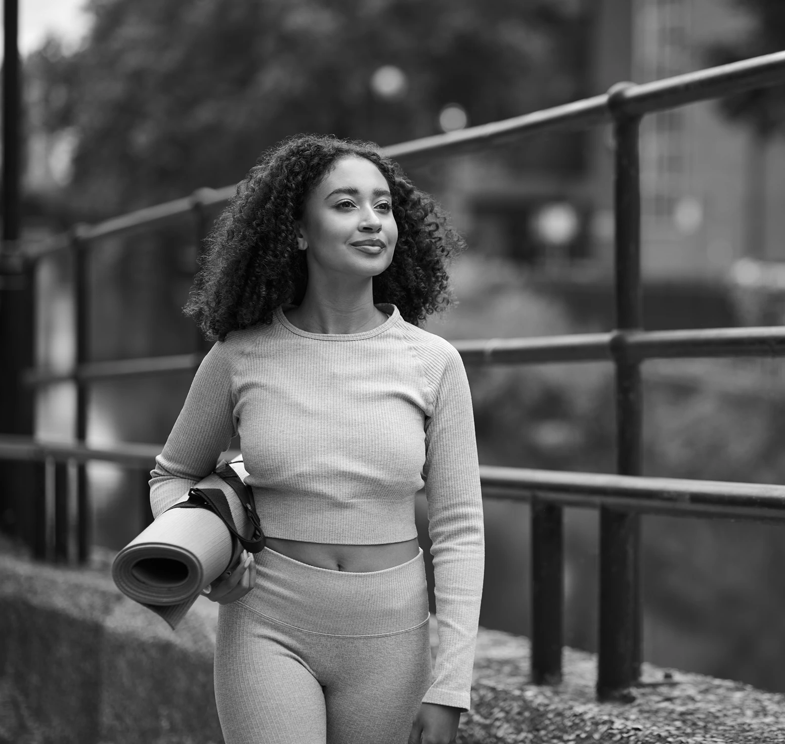 Confident woman walking with yoga mat