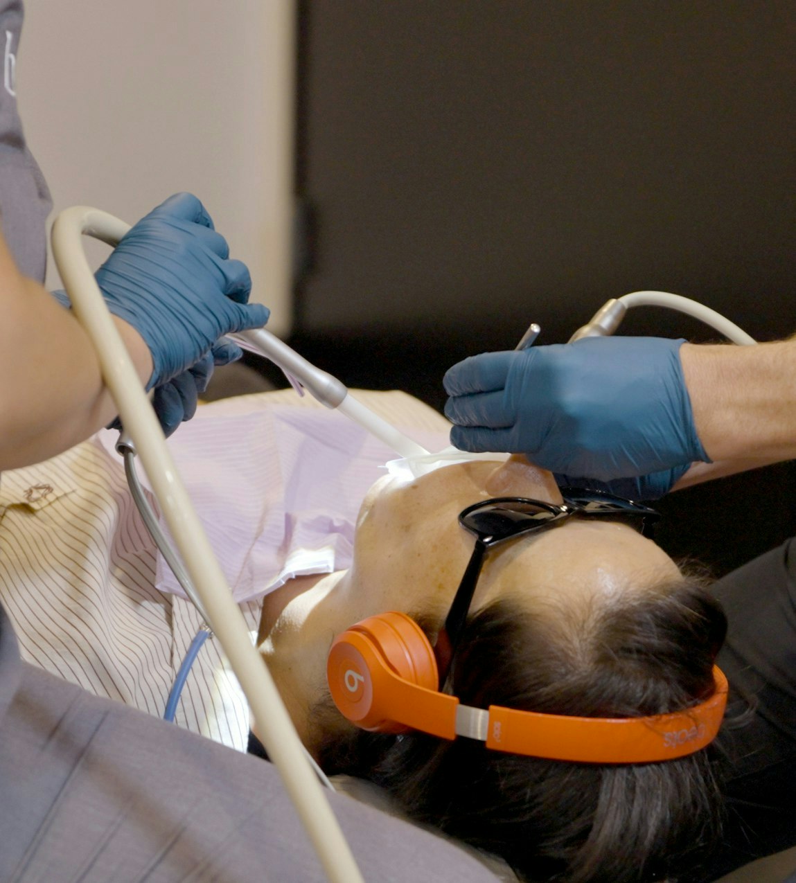 Patient relaxing with sunglasses and noise-cancelling headphones during a procedure