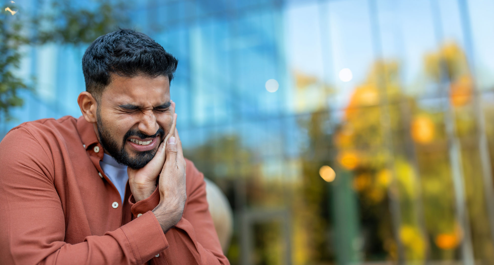 man holding his jaw in pain