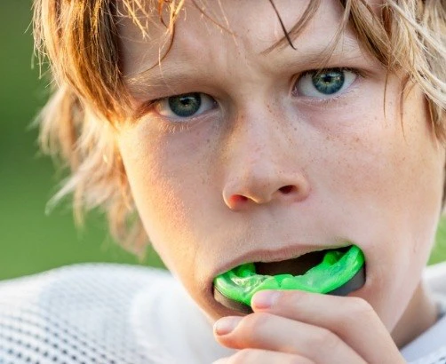 picture of young boy holding an athletic mouthguard