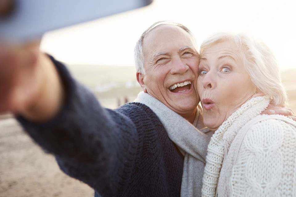 Older couple taking happy selfie