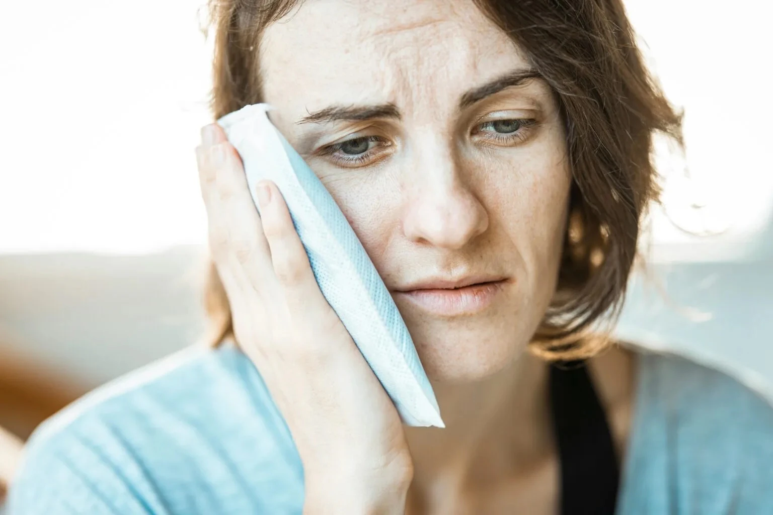 Woman holding tooth in pain