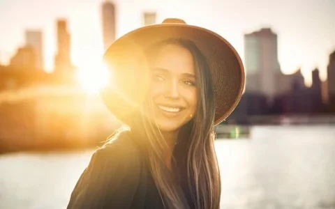 Woman in front of skyline at sunset