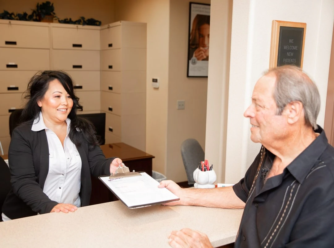 Front desk manager giving patient forms to fill out