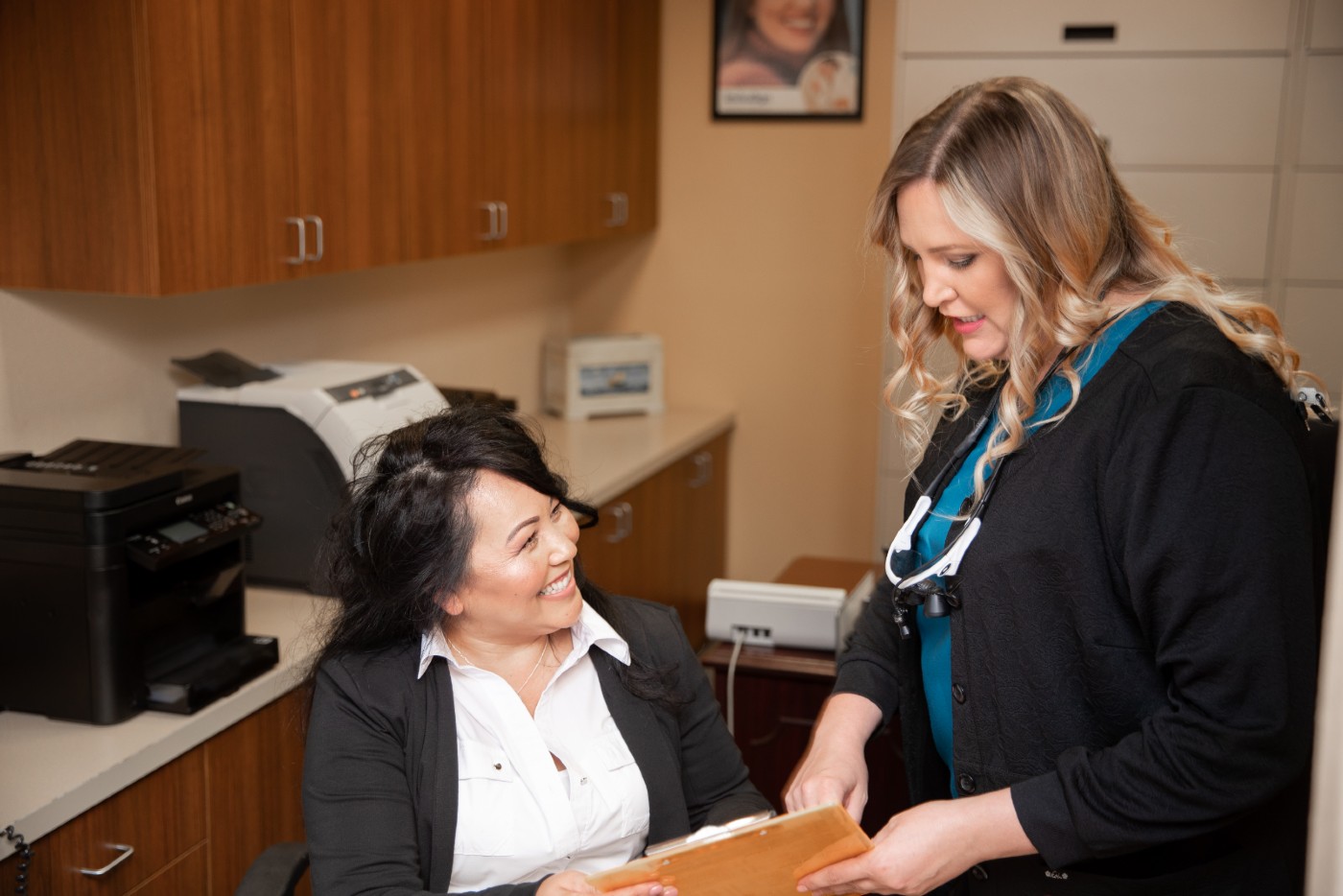 Front desk manager and dental hygienist going over paper work