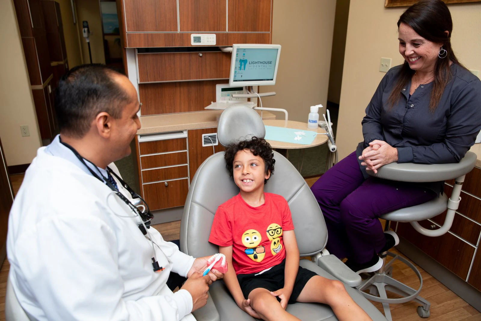 Alt: kid sitting in chair while doctor goes over brushing with him
