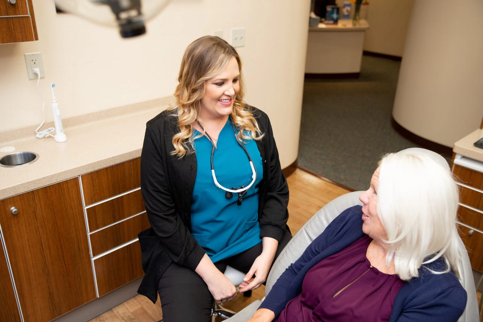 Dental hygienist and older patient laughing