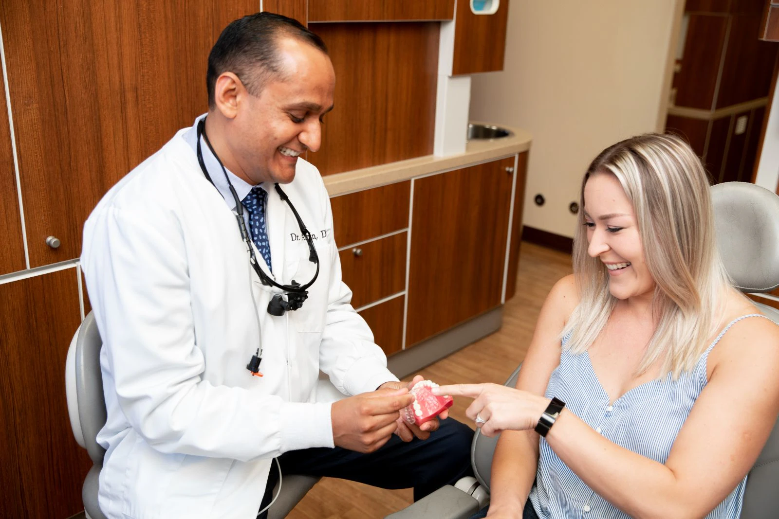 Doctor and patient looking at a clay mouth example