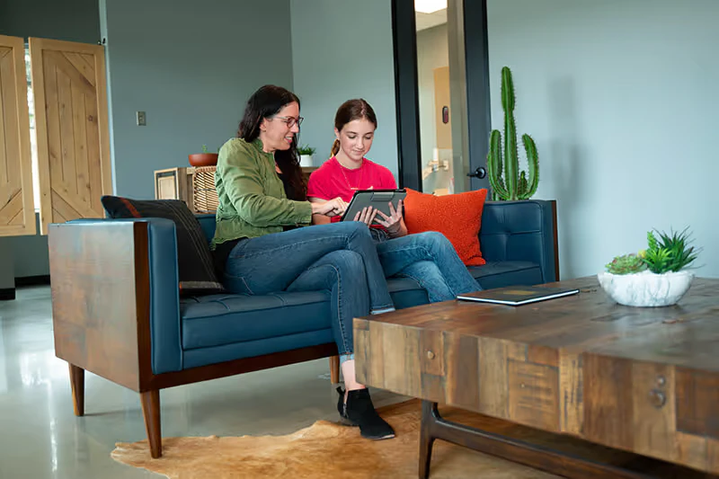 mother and daughter on a couch with iPad