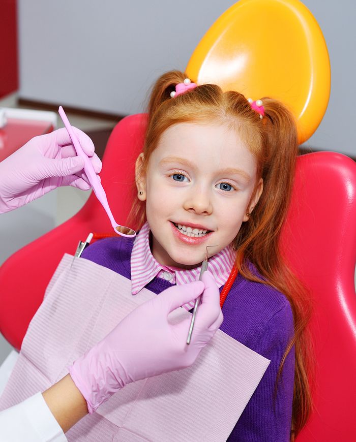 young girl in dental chair smiling