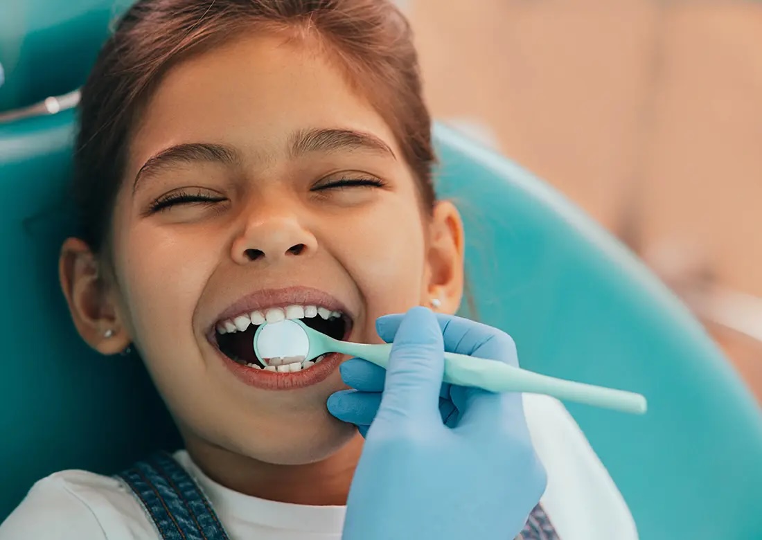 Laughing girl having her teeth examined