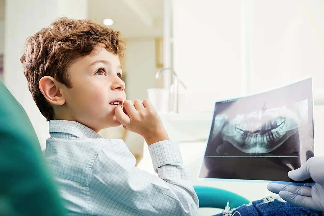 Dentist showing young boy his dental x-rays