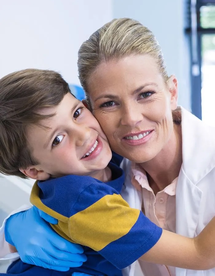 Dental staff posing with young boy