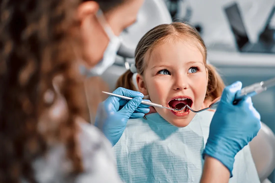 Girl getting her teeth examined